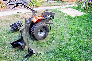 Plow and hiller complete with a walk-behind tractor for agricultural work. Copy space for text