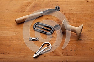 Plow, spool and tailor tools craft concept on wooden texture