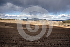 Plowed field, arable land, blue sky with clouds, landscape