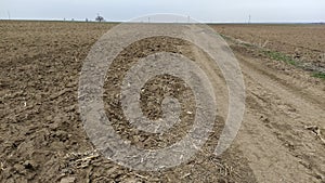 Plowed field. Arable land with fertile soil for planting crops. Rural landscape in Serbia, in the Balkans. Furrows and pits