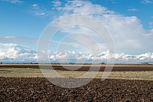 Plowed field in autumn time with blue sky