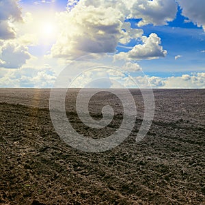 Plowed field and cloudy sky