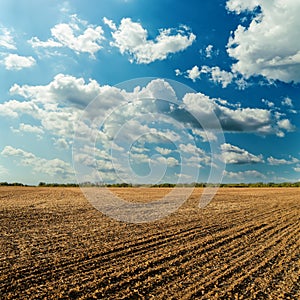 Plowed field and cloudy sky