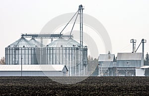 A plowed field in front of the grain-elevator complex