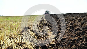 plowing in the field by a tractor with a trailed unit