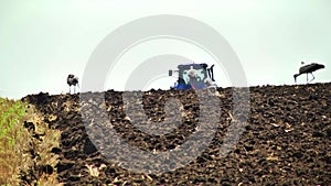 plowing in the field by a tractor with a trailed unit