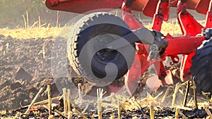 plowing in the field by a tractor with a trailed unit