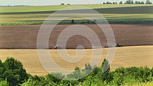 plowing in the field by a tractor with a trailed unit