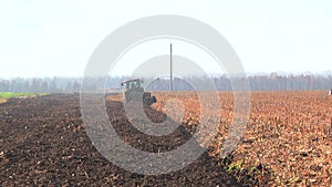 plowing in the field by a tractor with a trailed unit