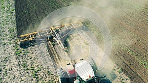 Plowing tractor works on a big field.