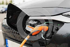 The plug of a charging cable is in an electric car