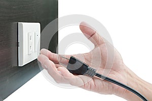 Plug on hand and socket on wall