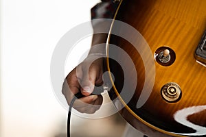 Plug jack cable in electric guitar,Hand inserts input jack to electric guitar
