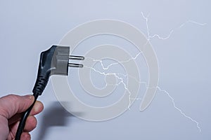 Plug in one hand save electricity and a branched lightning
