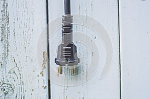 Plug from a power socket on a wooden background