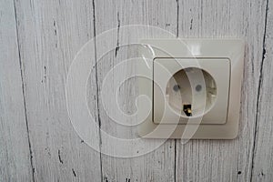 Plug socket outlet on the wooden house wall