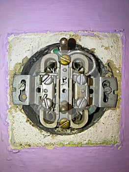 Plugged electrical socket without cover, old version, located in the wall