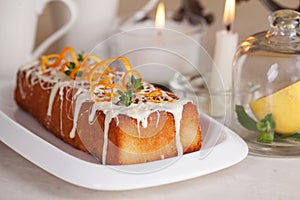 Plum cake food white chocolate, orange zest, thyme, close-up still life with tea and lemon