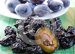 Plum and dried plum on a wooden background  prunes