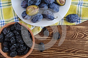 Plum and dried plum on a wooden background  prunes