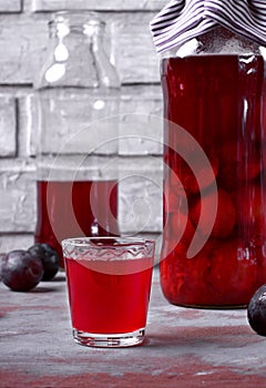 Plum liquor in a shot glass and bottles