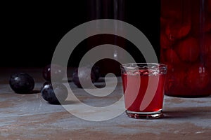 Plum liquor in a shot glass and bottles
