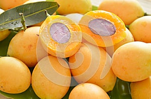 Plum mango tropical fruit produced in summer half cut on banana leaf