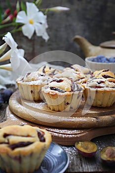 Plum muffins, powdered sugar dressing and teapot