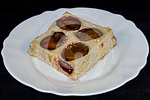 Plum-pie with cinnamon on a white plate