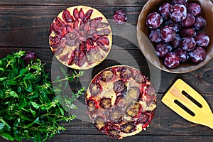 Plum pies on a dark wooden background.