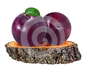 Plum on a wooden ÃÂross section of tree trunk isolated on white