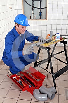 Plumber adjusting pipe photo