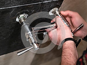 Plumber adjusts eccentrics of shower faucet valve