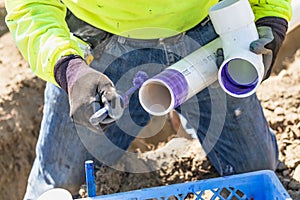 Plumber Applying Pipe Cleaner, Primer and Glue to PVC Pipes photo