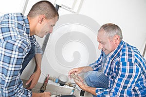Plumber and apprentice fitting central heating