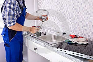 Plumber Assembling The Kitchen Sink Faucet