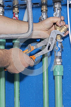 Plumber attaches to pipe gas boiler using adjustable wrench