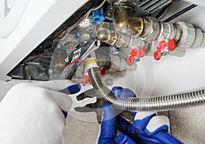 Plumber attaches to pipe gas boiler. photo