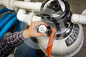 Plumber checking manometer on big hydraulic pump