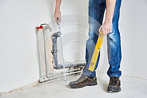 Plumber checks pipe vertical level after installation