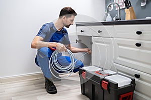 Plumber Cleaning Clogged Sink Pipe