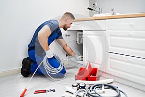 Plumber Cleaning Clogged Sink Pipe