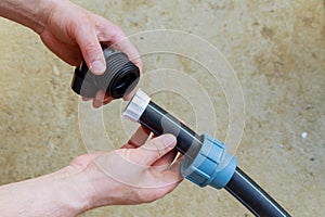A plumber connects a polyethylene pipe using a special fitting.