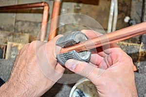 Plumber cutting copper pipe