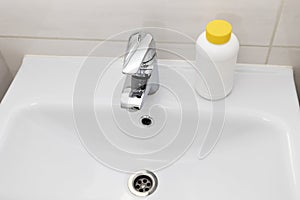 Plumber drain granules in White Plastic Bottle With Yellow Cap On Bathroom Sink In Shower