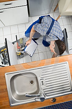 Plumber examining kitchen sink