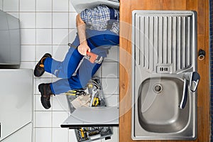 Plumber examining kitchen sink