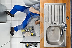 Plumber examining kitchen sink