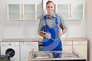 Plumber With Faucet In Kitchen Room