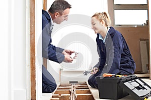 Plumber And Female Apprentice Fitting Central Heating